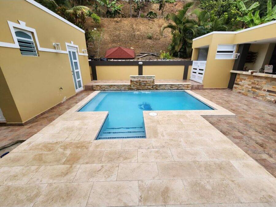 Piscina con jacuzzi integrado, deck de travertino y área de BBQ