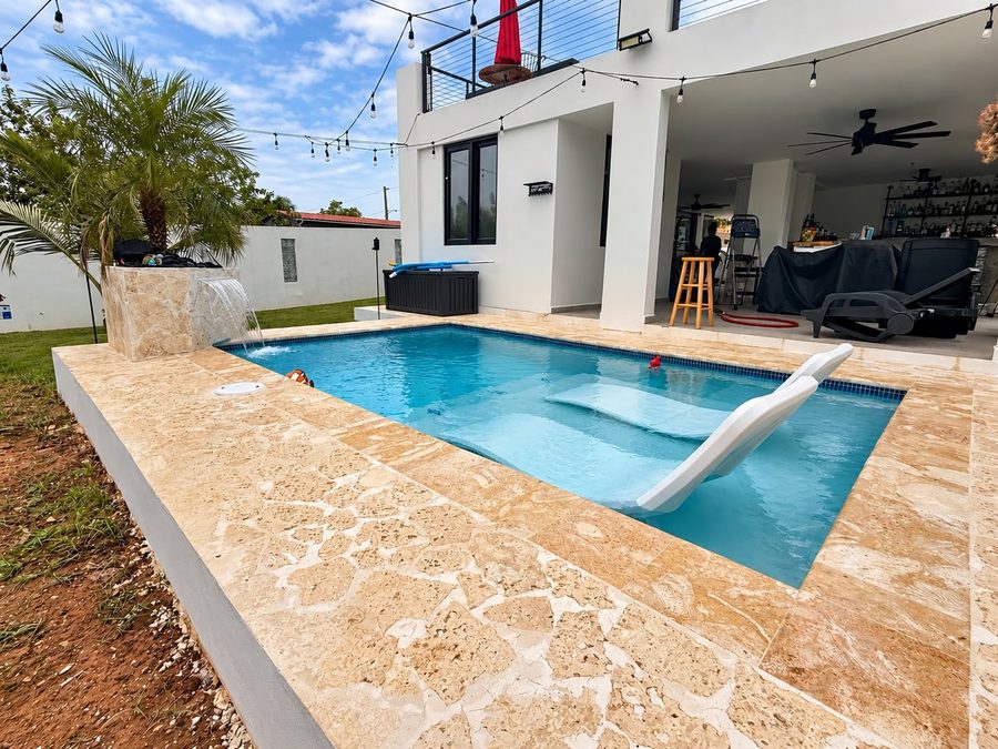 Piscina con sundeck y sillas lounge dentro del agua