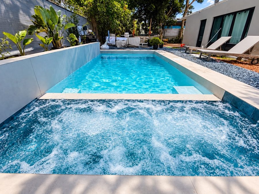 Jacuzzi integrado con los chorros encendidos frente a la piscina