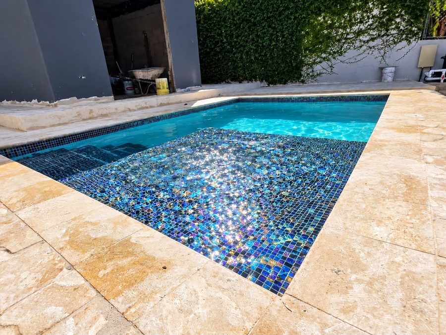 Piscina en mosaico vidriado con aceras de travertino
