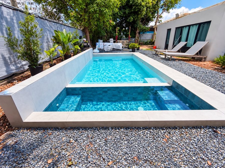Piscina con jacuzzi integrado y muro elevado