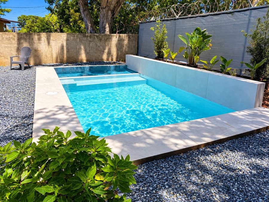 Piscina con aceras en porcelanato y jardín